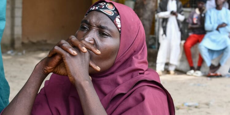 A family member of a victim of the Islamist terror group Boko Haram clasps her hands together in Babban Gide on Sept. 4, 2024.