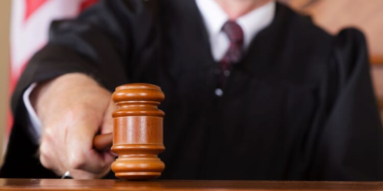 A close-up image of a judge holding a gavel.