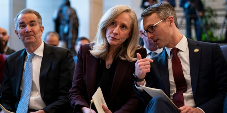 Former Virginia Governor Ralph Northam, then-Governor-elect Abigail Spanberger, and Representative James Walkinshaw sit together at an unveiling ceremony for the statue of a civil rights leader in Emancipatino Hall in the U.S. Capitol Visitors Center in Washington on Dec. 16, 2025.