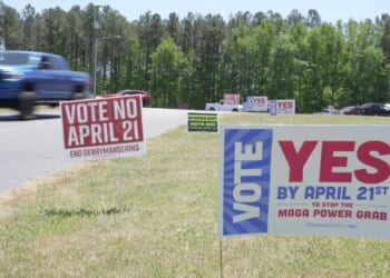 A truck passes political signs outside a polling place at Good Shepherd Catholic Church in South Hill, Virginia, on April 21, 2026.