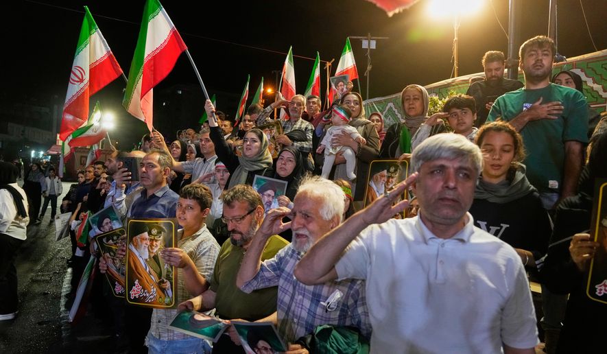 Government supporters stand for Iran's national anthem during a pro-government gathering at Islamic Revolution Square in Tehran, Iran, Wednesday, May 13, 2026. (AP Photo/Vahid Salemi)