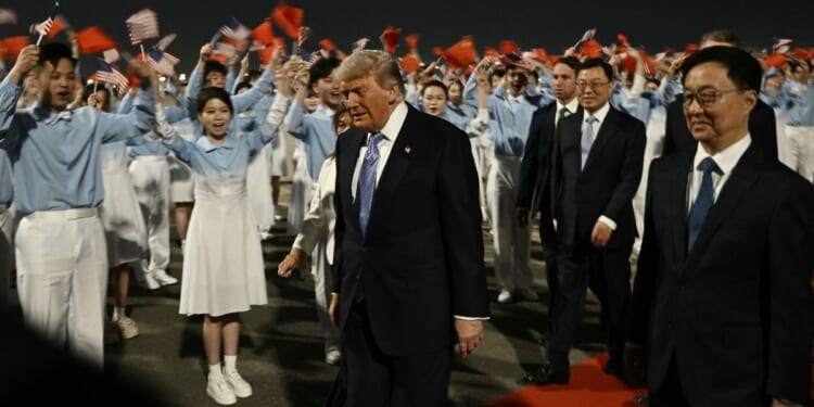 President Donald Trump is escorted by China's Vice President Han Zheng, right, upon his arrival at Beijing Capital Airport Wednesday.