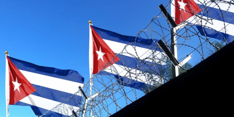 The Cuban flag flies above the walls of a prison.