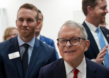 Gov. Mike DeWine appears for a factory tour while smiling.