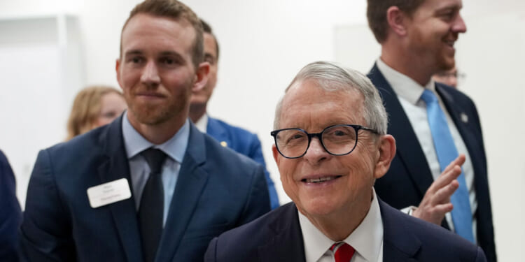 Gov. Mike DeWine appears for a factory tour while smiling.