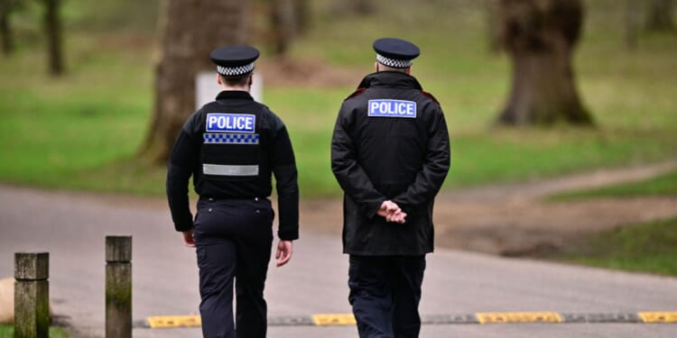 Police officers walk through the Bishops Gate entrance leading to Royal Lodge, a 30-room property and former residence to Britain's former prince Andrew where police said they are still conducting a search, in Windsor, west of London, on Feb. 20, 2026.