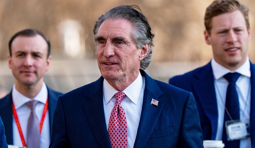 Interior Secretary Doug Burgum, center, is seen at the White House, March 11, 2026, in Washington. (AP Photo/Alex Brandon, File)