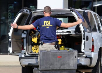 An FBI agent gathers evidence outside the Armed Forces Career Center in Chattanooga, Tennessee, on July 16, 2015.