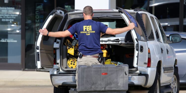 An FBI agent gathers evidence outside the Armed Forces Career Center in Chattanooga, Tennessee, on July 16, 2015.