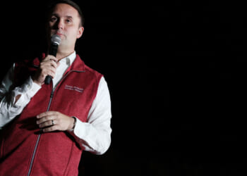 Former Virginia Attorney General Jason Miyares, wearing a red vest, speaks.