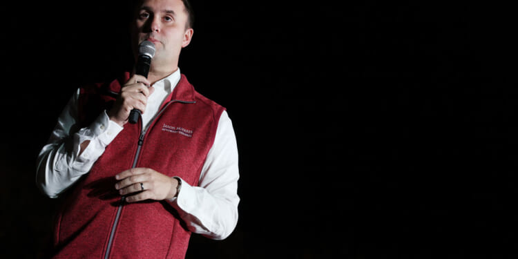 Former Virginia Attorney General Jason Miyares, wearing a red vest, speaks.
