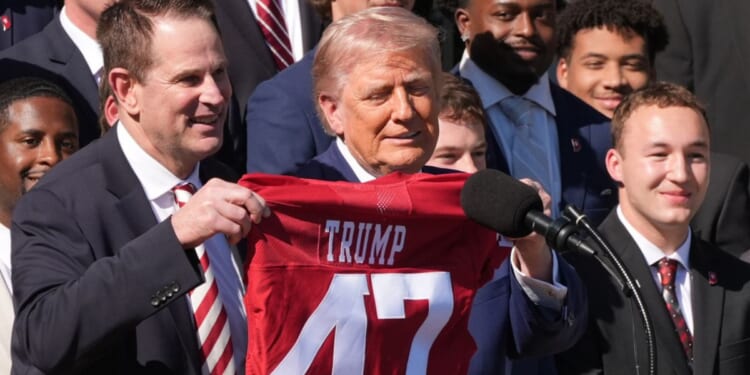 Indiana Hoosiers coach Curt Cignetti, left, presents President Donald Trump a jersey during an event to welcome the 2026 College Football Playoff national champions Indiana University on the South Lawn of the White House, Monday.