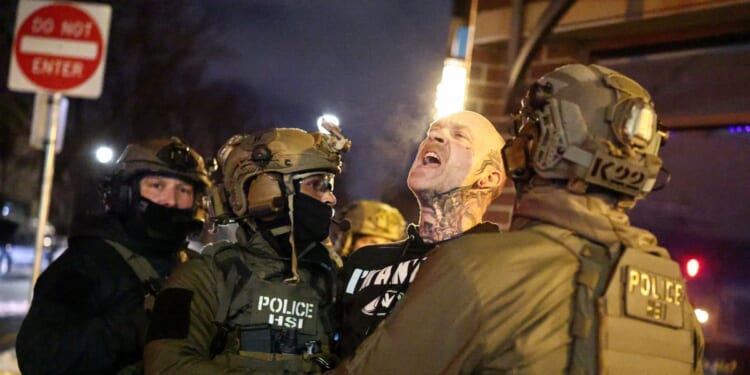 Federal agents with Homeland Security Investigations detain a protestor wearing an "Antifa" shirt outside a residential building in Minneapolis, Minnesota, on Feb. 5, 2026.