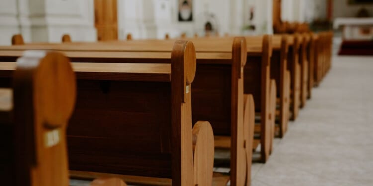 Rows of empty pews inside a church.