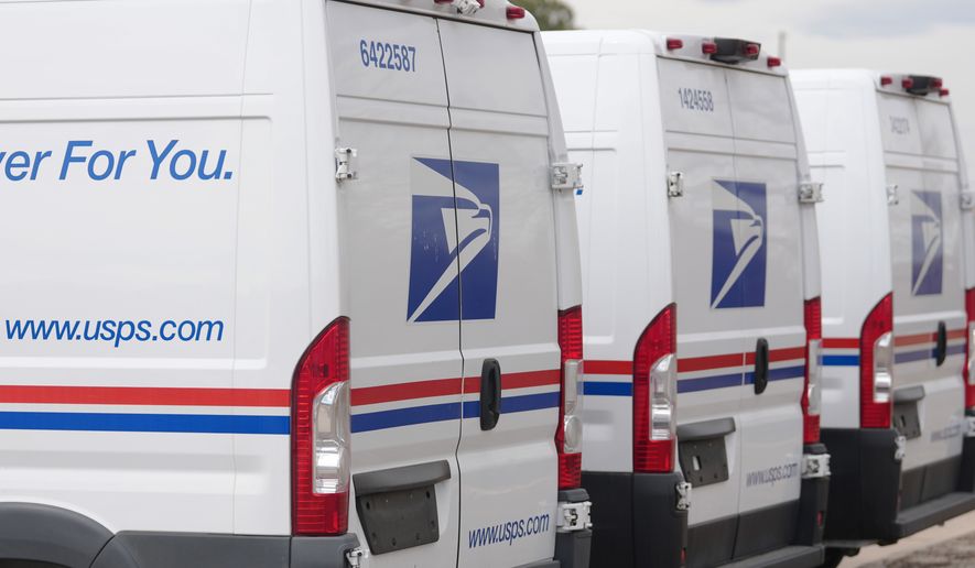 The United States Postal Service logo is shown on delivery vans parked outside the main post office in east Denver on March 23, 2026. (AP Photo/David Zalubowski) **FILE**