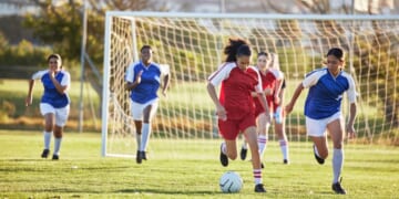 A girl's soccer team practices on a sunny day.