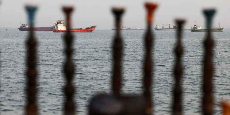 Tankers on the Strait of Hormuz as seen through posts on an Iranian beach.