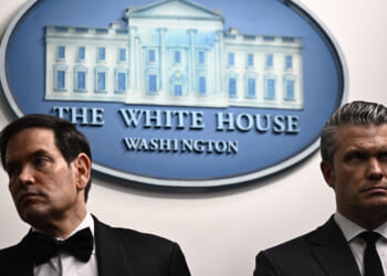 A stern looking Marco Rubio and Pete Hegseth stand together in White House briefing room.