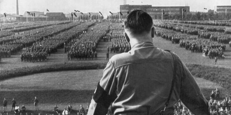 German Fuhrer and Nazi leader Adolf Hitler addresses soldiers with his back facing the camera at a Nazi rally in Dortmund, Germany.