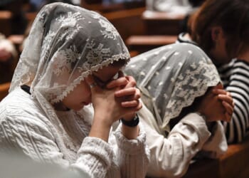Two girls and one woman, all praying