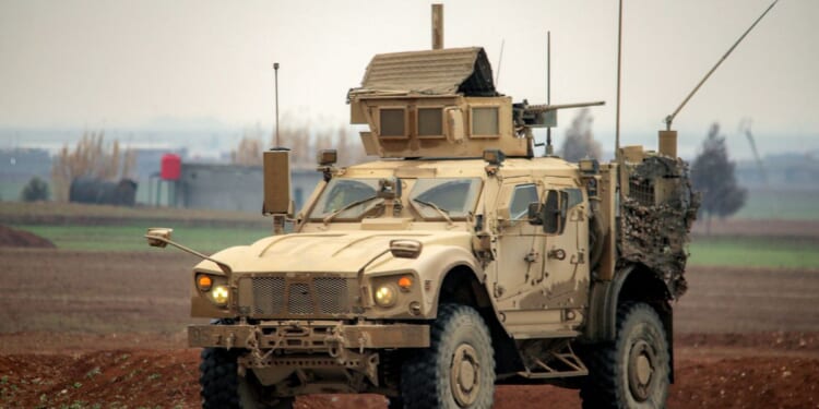 A U.S. military mine-resistant ambush protected vehicle moves along a road in a convoy transporting Islamic State group detainees being transferred to Iraq from Syria, on the outskirts of Qahtaniyah in Syria's northeastern Hasakah province on Feb. 7, 2026.