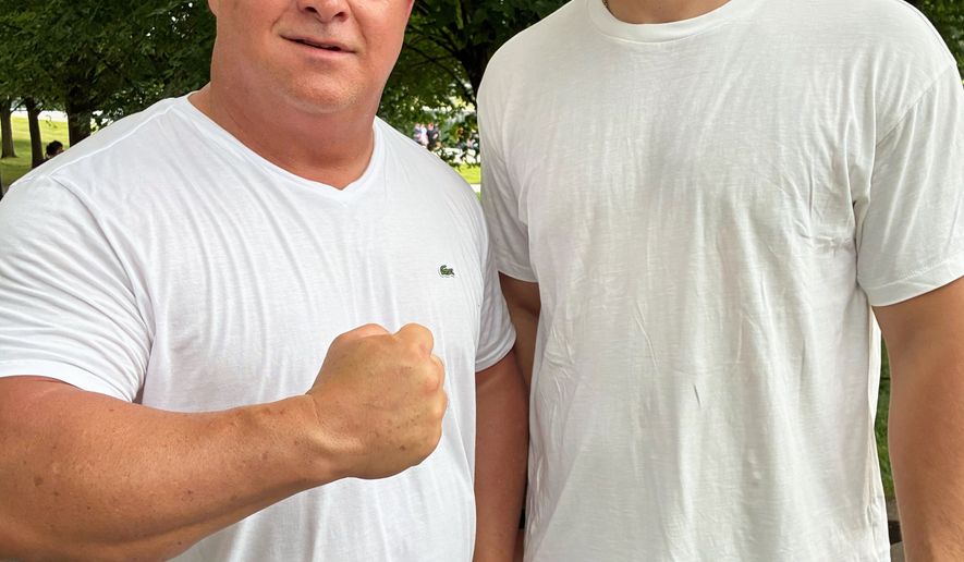 Tracy Philbeck and his son, Levi Philbeck, from Charlotte, N.C., pose for a photo at the Lincoln Memorial, Friday, June 12, 2026, in Washington. (AP Photo/Fatima Hussein)