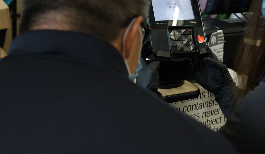 A fake overlay keypad skimming device is removed by USDA IG John Walk and a Secret Service agent. (Photo by Noah Hudson)