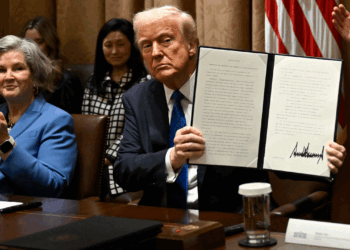 President Donald Trump, center, shows off a signed executive order with his Chief of Staff Susan Wiles, left, and Director of Presidential Personnel Sergio Gor, right, during a meeting with ambassador nominees in the Cabinet Room at the White House in Washington, DC on March 25, 2025. (Photo by John McDonnell/For The Washington Post via Getty Images)