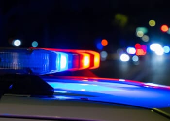 A crime scene in a city at night with blue and red police lights.
