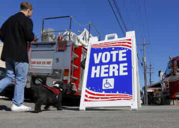 A man walks a dog past a polling station on December 10, 2016 in New Orleans, Louisiana. Louisiana residents head to the polls on Saturday to select a U.S. Senator in a runoff election between Democratic candidate Foster Campbell and Republican candidate John Kennedy. (Photo by Jonathan Bachman/Getty Images)