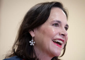 Jane Timken looks to the side and smiles.