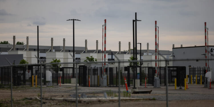 An outside view of a data center in Hilliard, Ohio behind a fence.