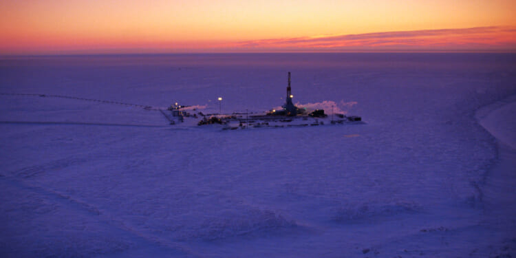 An oil well at Alaska's Prudhoe Bay as the sun sets.