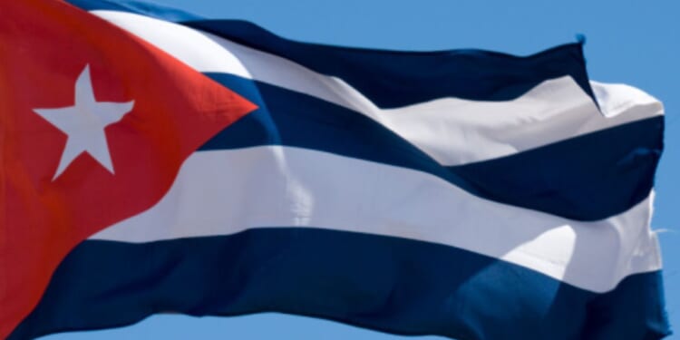 Cuban flag flies in the blue skies.