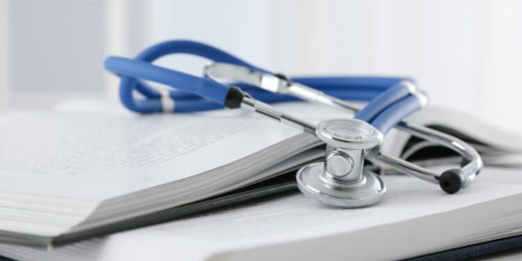 A stethoscope sits on a stack of books.