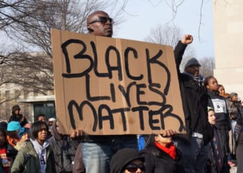 Racial activist protesters hold up a Black Lives Matter sign on Pennsylvania Avenue in Washington on Dec. 13, 2014.