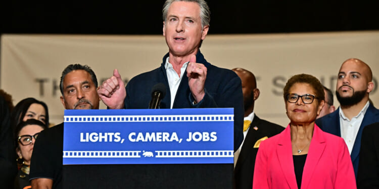 California Governor Gavin Newsom, alongside Los Angeles Mayor Karen Bass (2R), speaks at a news conference, where he announced a major expansion of the state's film and TV tax credit program, raising the cap to $750 million in an effort to keep entertainment productions in California, at the Ranch Lot Studios in Burbank, California on July 2, 2025. (Photo by Frederic J. BROWN / AFP) (Photo by FREDERIC J. BROWN/AFP via Getty Images)