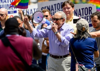 Senate Minority Leader Chuck Schumer speaks into a bullhorn while marching in Sunday's "pride" parade in New York City.