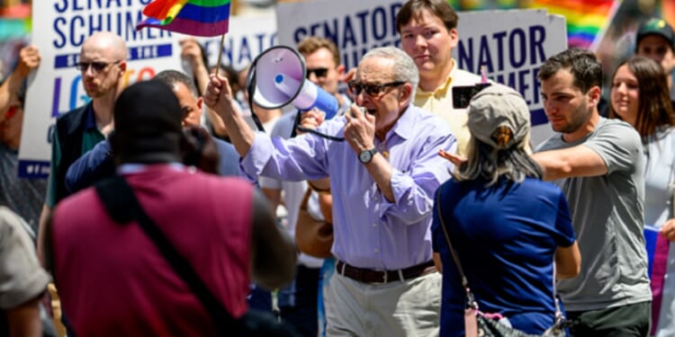 Senate Minority Leader Chuck Schumer speaks into a bullhorn while marching in Sunday's "pride" parade in New York City.