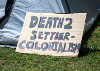 A Gaza solidarity encampment sign reads 'Death to Settler Colonialism.'