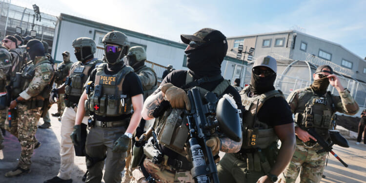 ICE agents confront protesters as they gather outside the federal immigration center.