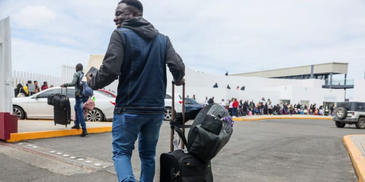 Lovenstar, a Haitian rap artist, joins hundreds of asylum seekers who used a CBP phone app to schedule an interview with U.S. agents at the San Ysidro Border Crossing in Tijuana, Mexico, on April 25, 2024.