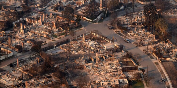 In this aerial view taken from a helicopter, homes burned from the Palisade fire smolder near the Pacific Palisades neighborhood of Los Angeles, California, on Jan. 9, 2025.
