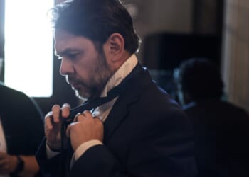 Senator Ruben Gallego ties his tie as he walks to the Senate Chambers on May 11, 2026.