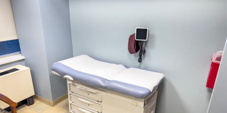 An empty examination table in a doctor’s office.