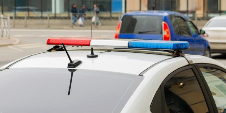 A police car with flashing lights is pictured in a stock photo. 