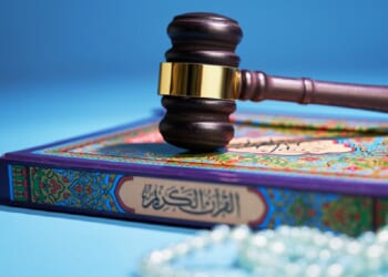 A gavel sits atop a Quran and Islamic prayer beads in a photo illustration.