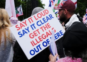 An anti-immigration sign is held by a protester at the Unite the Kingdom rally in London on May 16, 2026.