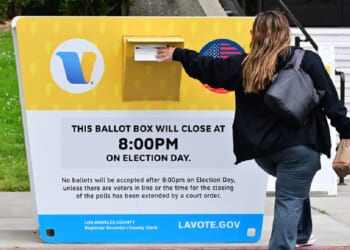 A voter drops a ballot in a drop box Monday at the Los Angeles County Registrar during early voting in the state's primary election.
