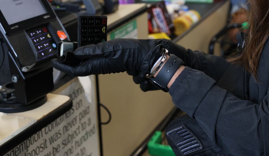 A fake overlay keypad skimming device is removed by USDA IG John Walk and a Secret Service agent. (Photo by Noah Hudson)
